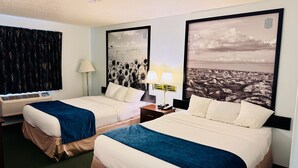 A hotel room with two beds, a nightstand, a lamp, and a large window. - Four Seasons Inn (Bottineau)