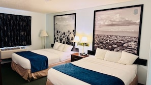 A hotel room with two beds, a nightstand, a lamp, and a large window. - Four Seasons Inn (Bottineau)