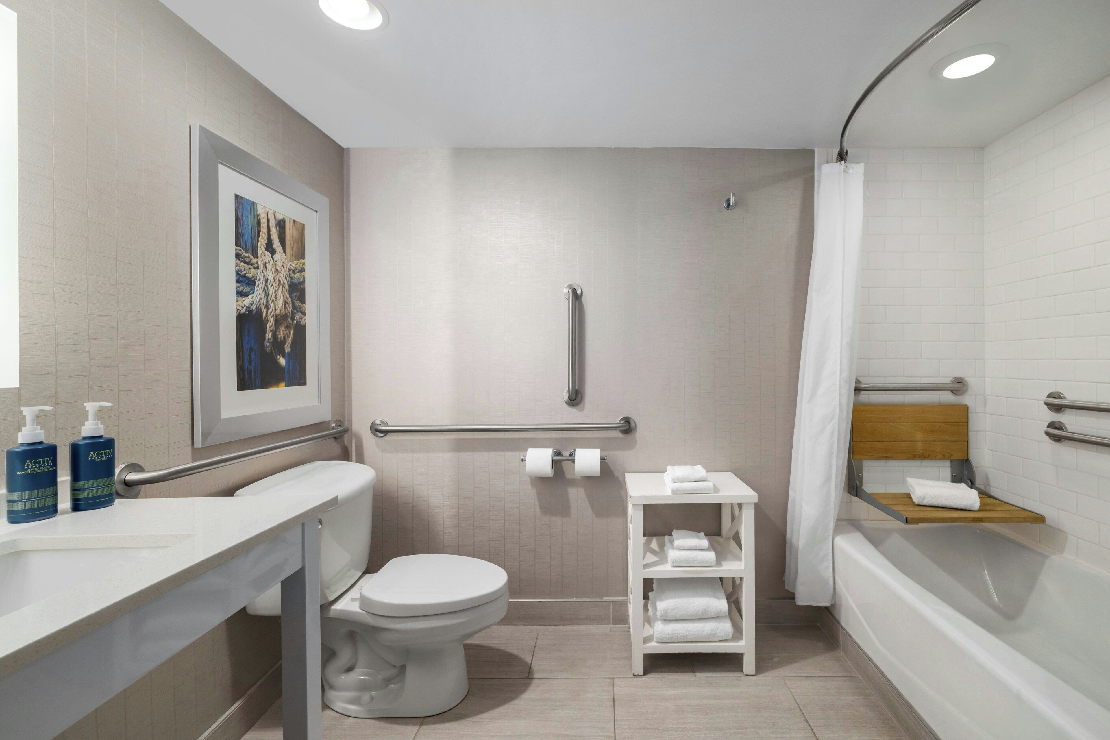 Et moderne badeværelse med toilet, bruser og håndvask.