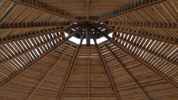 A wooden gazebo with a view of the ocean.