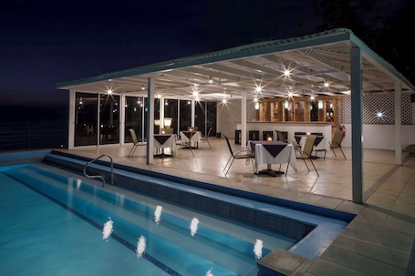 Una piscina al aire libre, sillones reclinables de piscina