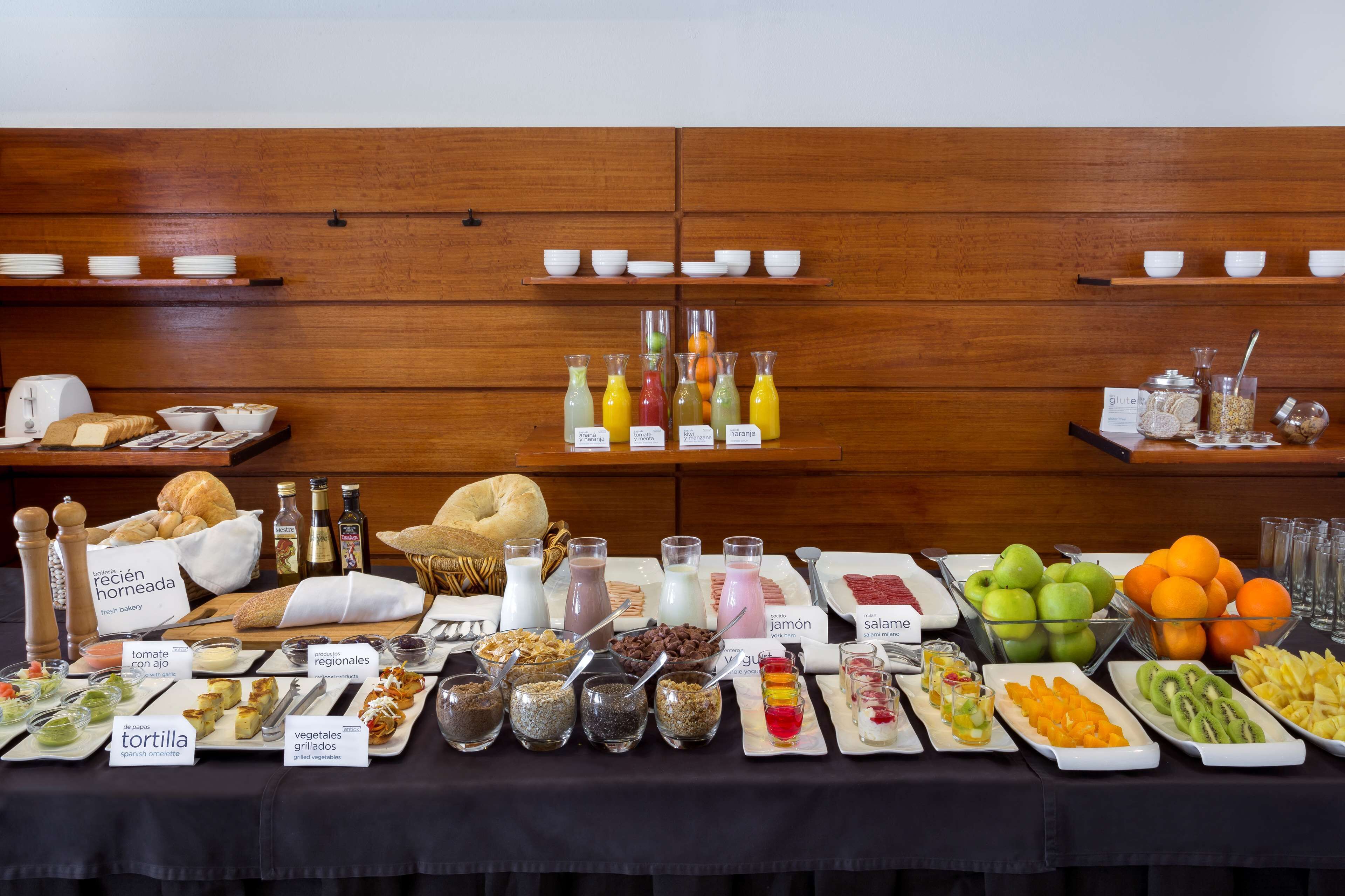 A buffet with various food and drink options, including fruits, vegetables, and beverages.