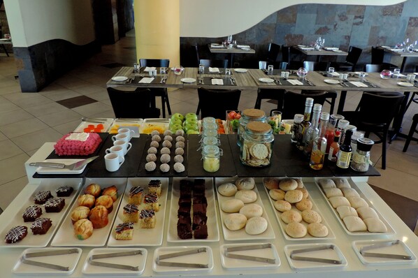 Una mesa de buffet con diversos alimentos y utensilios.