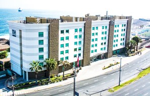 A hotel with a modern architectural design, featuring a prominent corner location with a view of the ocean. - NH Antofagasta (Antofagasta)