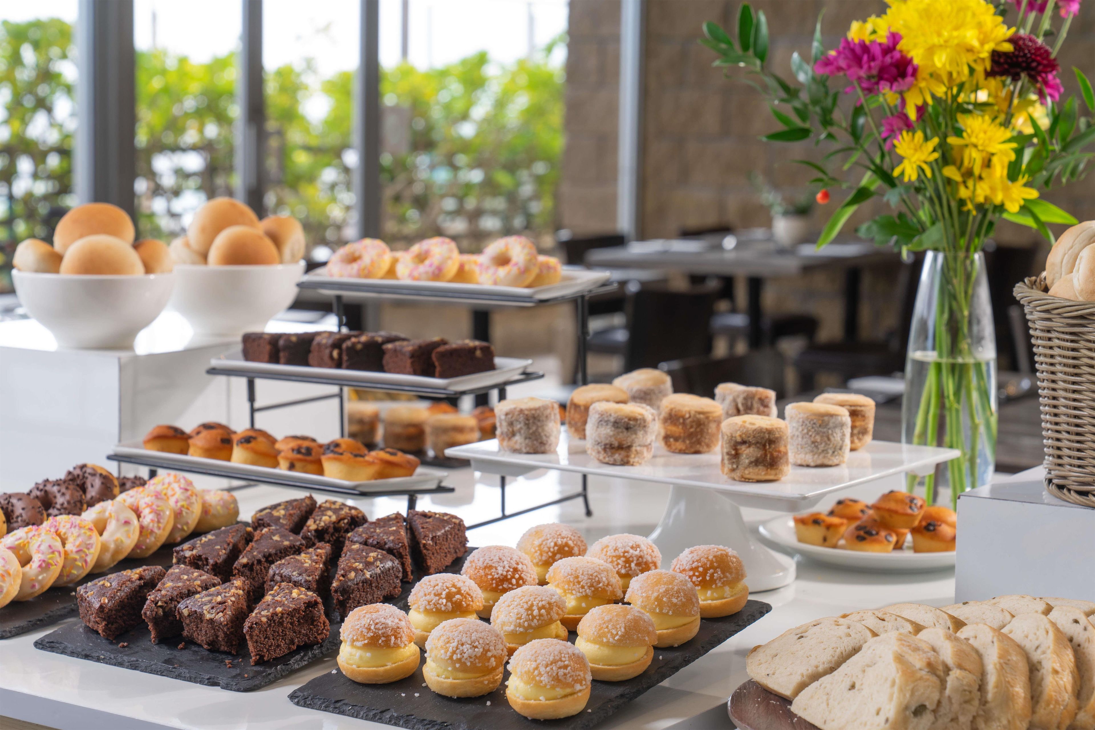 Un buffet proposant une variété de produits de boulangerie, notamment du pain, des viennoiseries et des desserts.