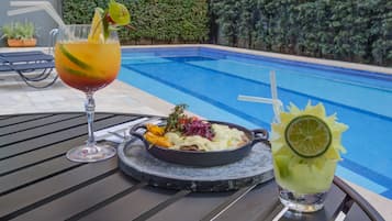 Una piscina al aire libre de temporada, sombrillas