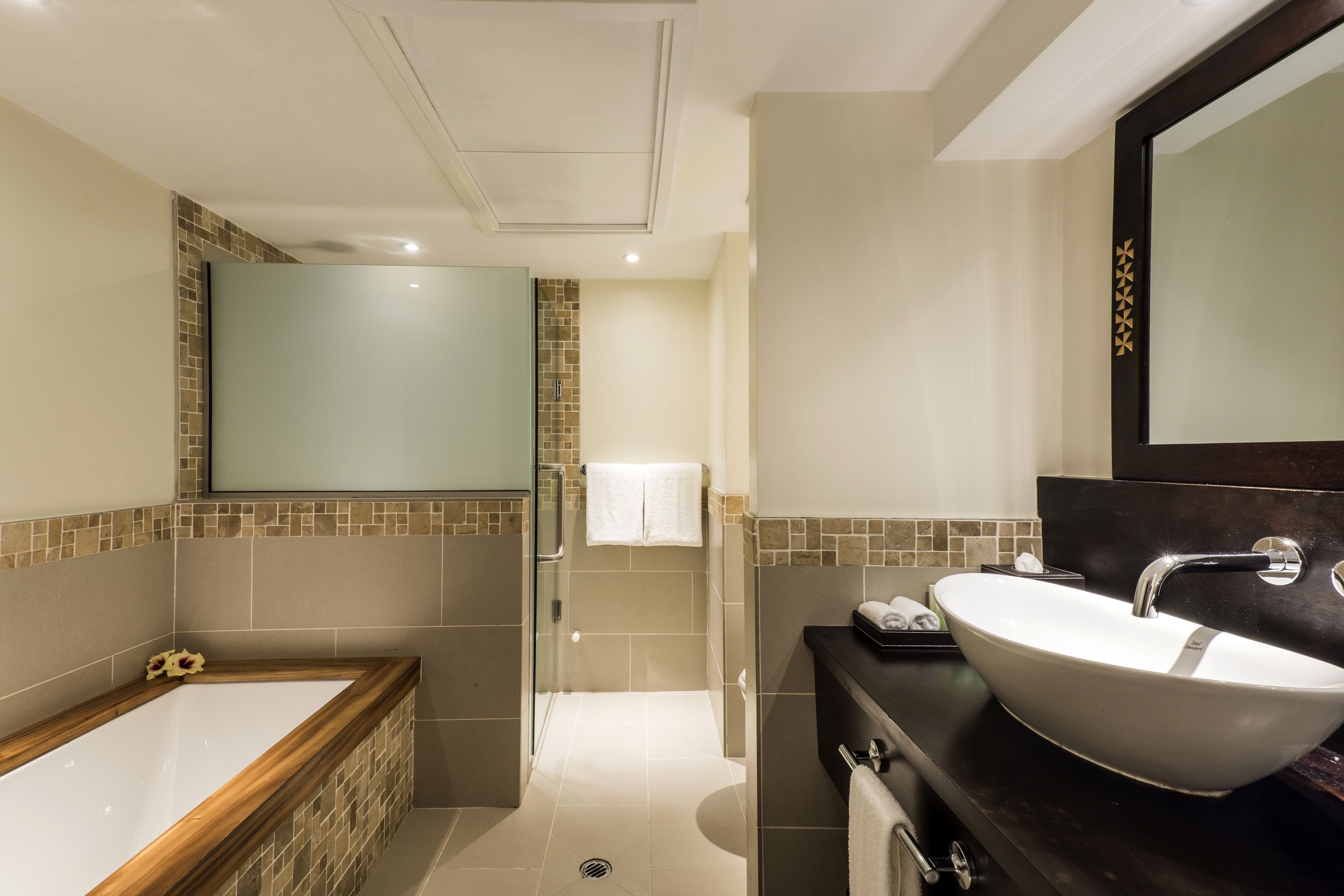 Een moderne badkamer met een vrijstaand bad, een groot wastafel en een inloopdouche.