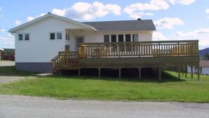 A single-story house with a front porch and a small deck.