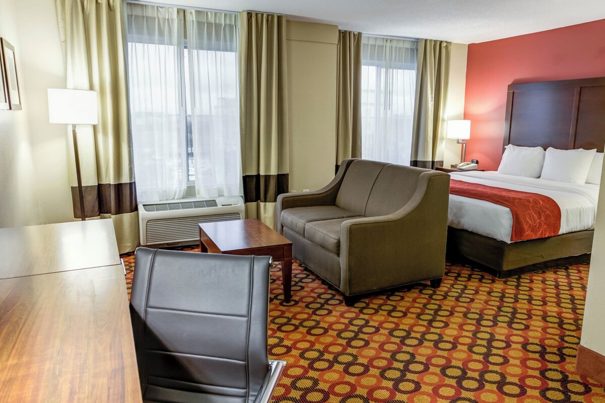Une chambre d’hôtel avec un lit, un canapé, un bureau et une chaise.