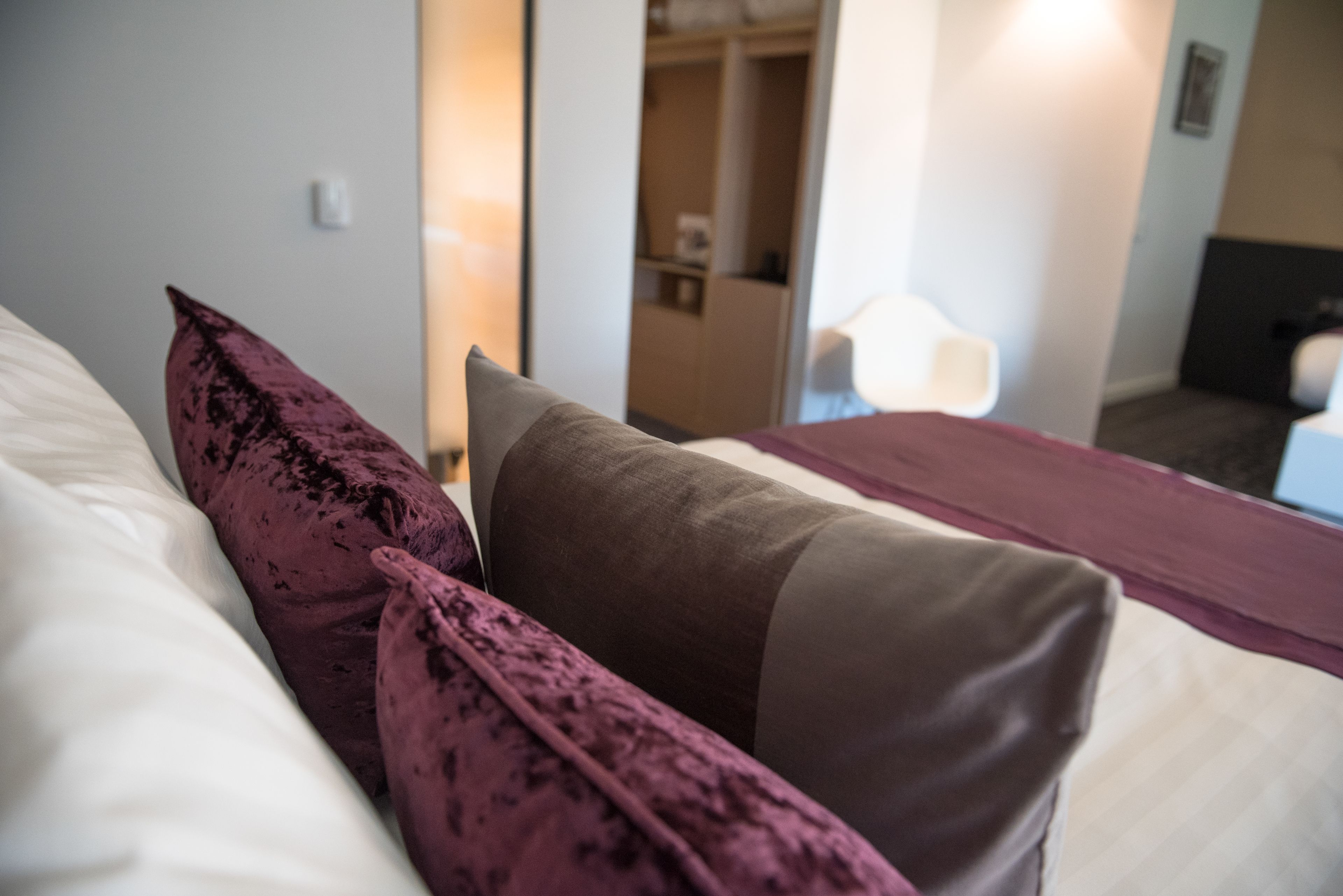 Une chambre d’hôtel avec un lit, une table de chevet et une armoire.