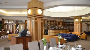 A hotel lobby with a reception desk, seating area, and bar. - Golden Jubilee Hotel (Clydebank)