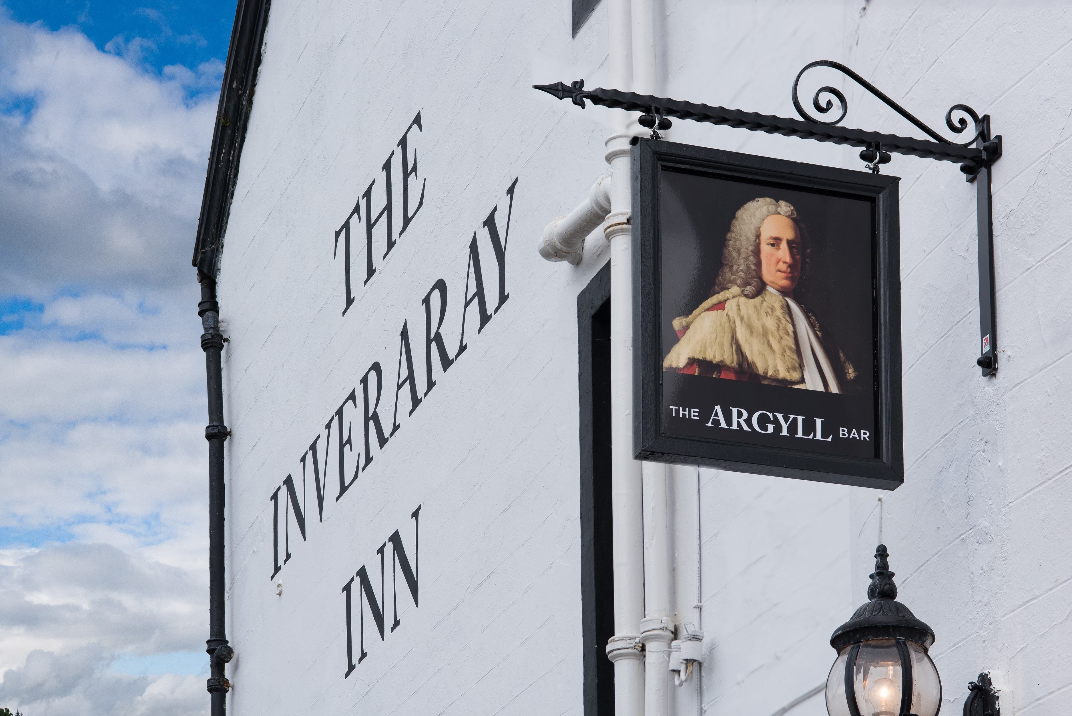 A sign for 'The Inveraray Inn' with a portrait of a historical figure and the name of the establishment.