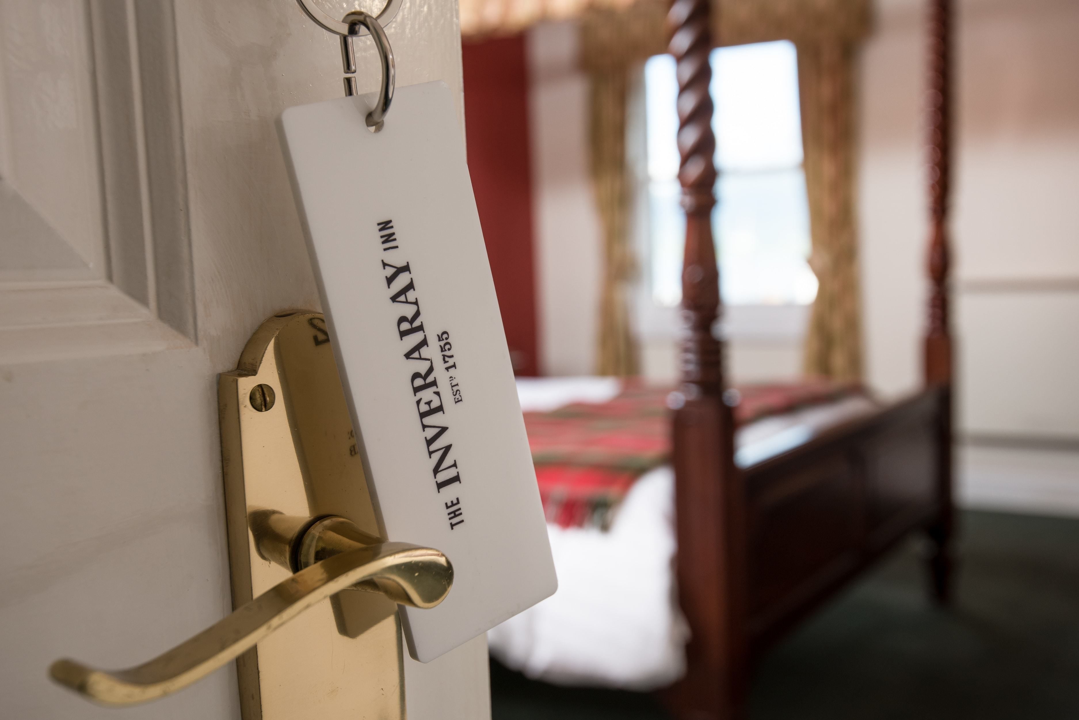 A door with a brass handle and a sign that reads "The Inveraray Inn."