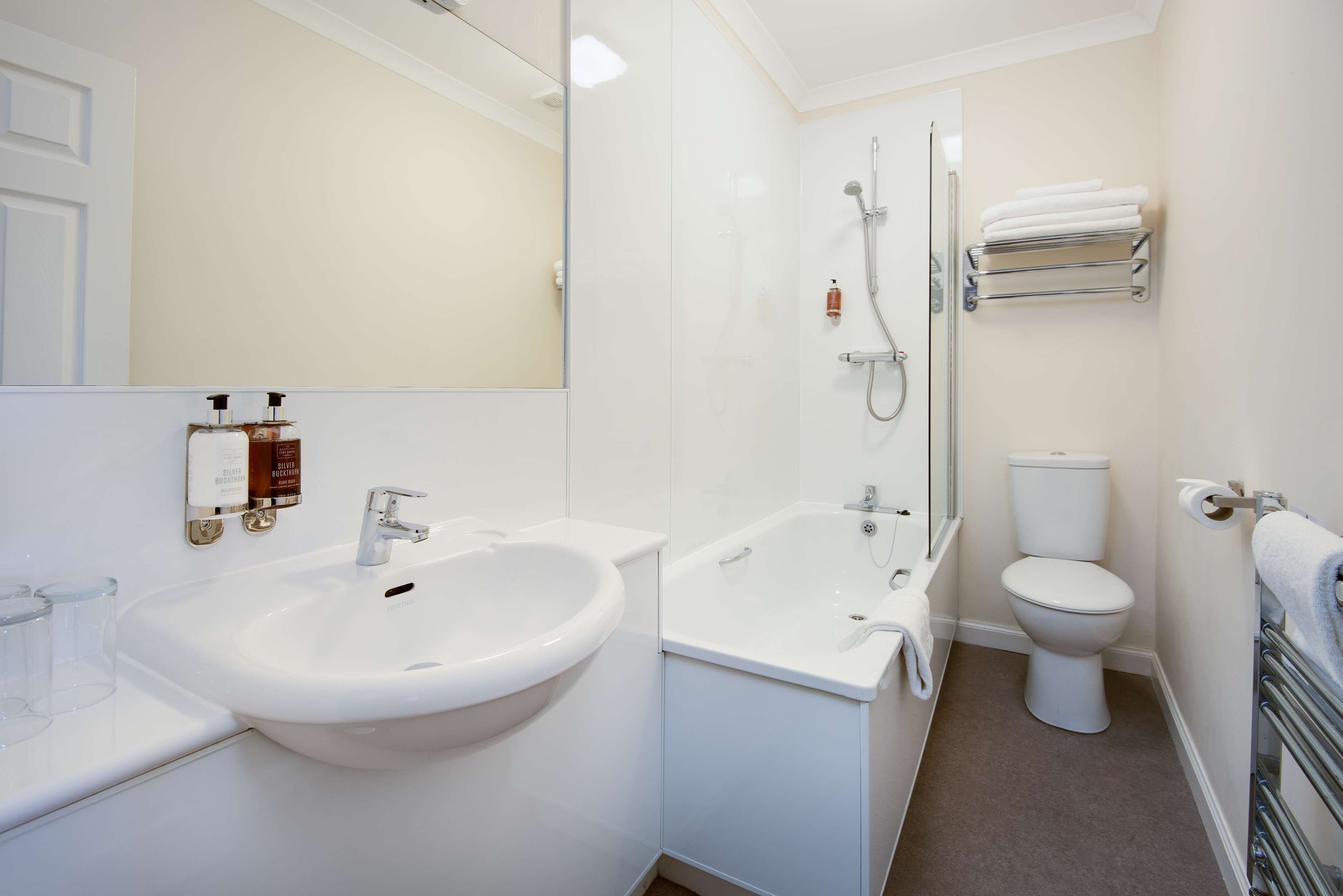 A modern bathroom with a sink, bidet, toilet, and a glass shower enclosure.