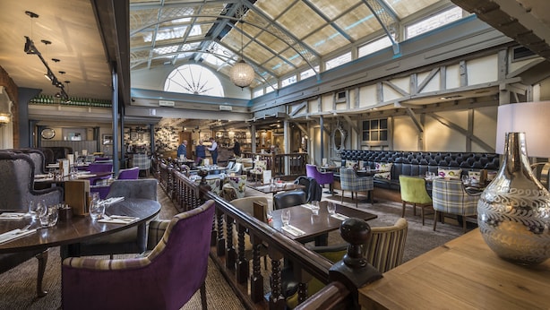 A spacious restaurant with high ceilings and a skylight, featuring a variety of seating options including tables and booths. - The Admiral Rodney Hotel, Horncastle, Lincolnshire (Horncastle)