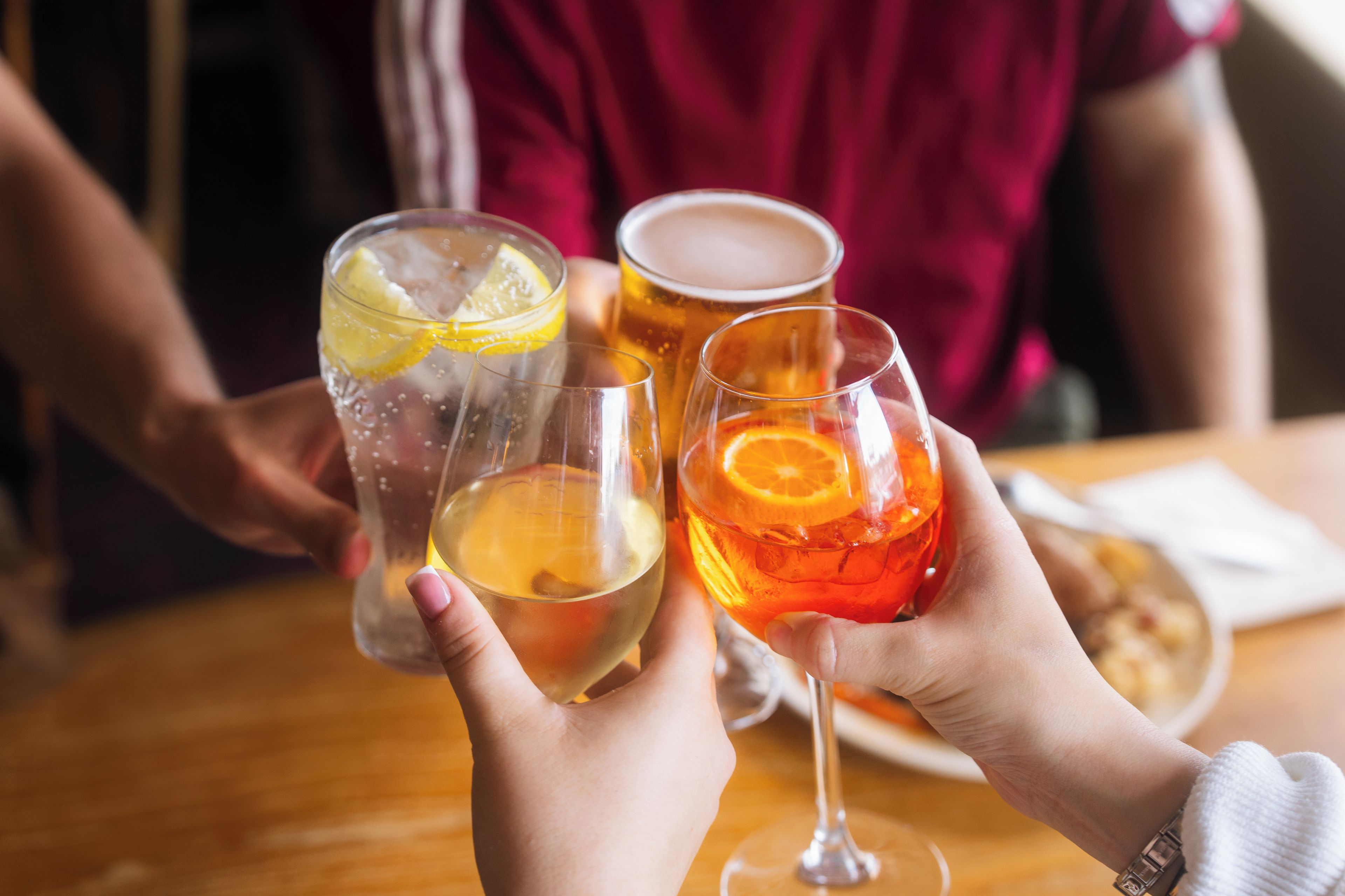 A person holding a glass with a lemon slice.