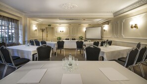 A conference room with round tables, chairs, and a projector screen. - The Admiral Rodney Hotel, Horncastle, Lincolnshire (Horncastle)