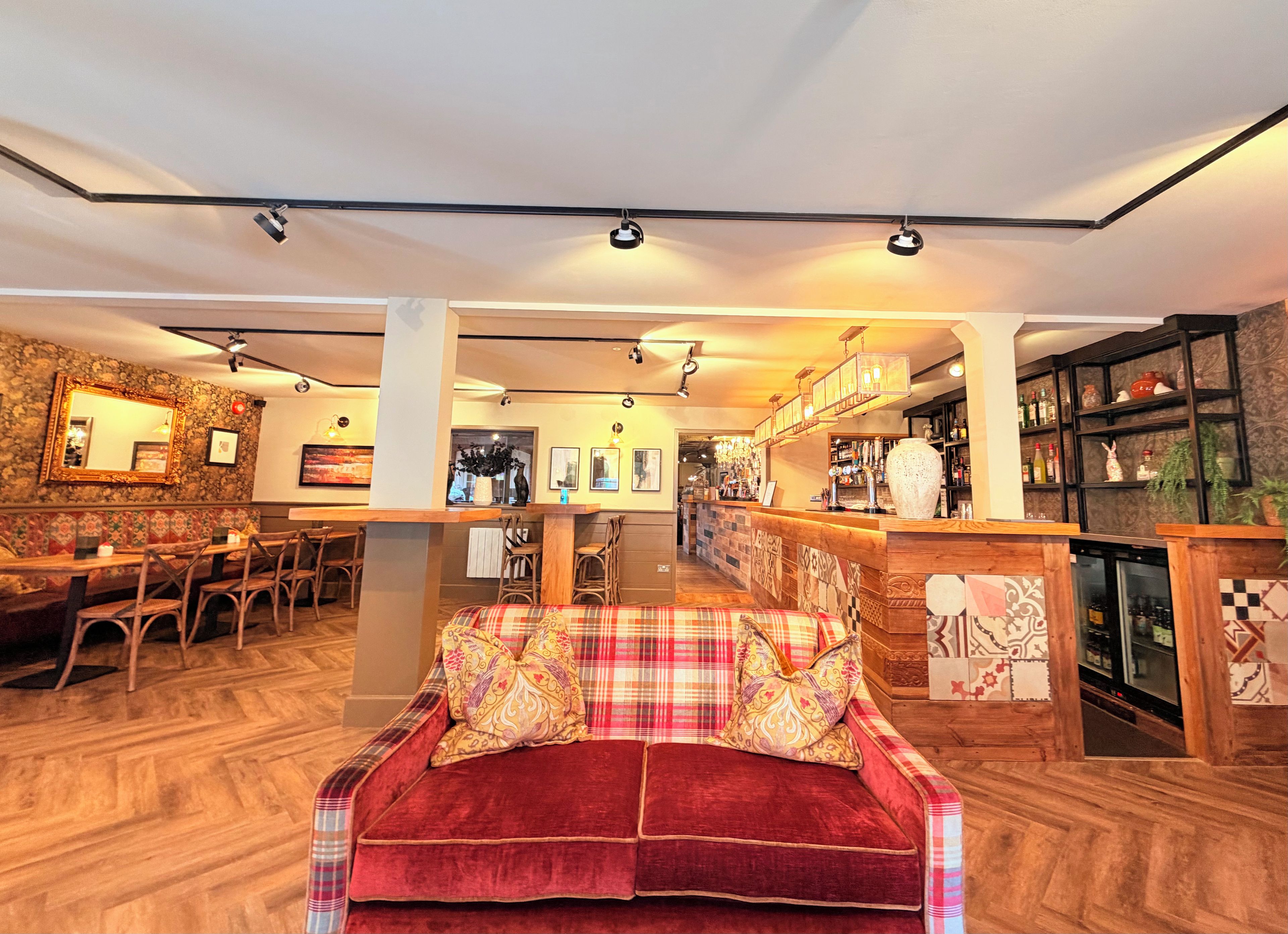 A hotel lobby with a bar area, seating arrangements, and a fireplace.