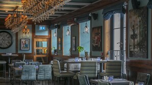 Un restaurante con vigas de madera, candelabros y cuadros enmarcados en las paredes.
