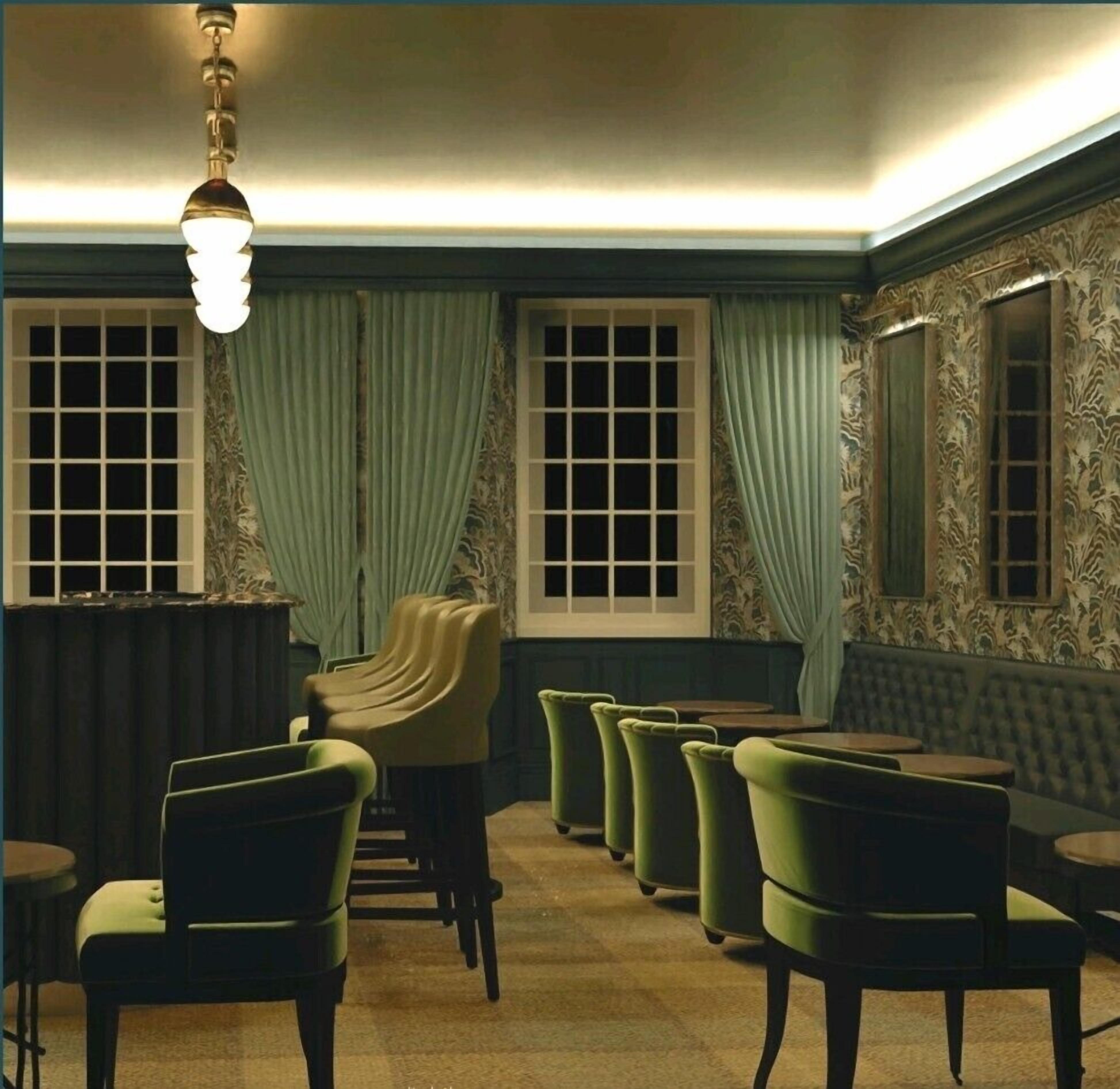A room with a seating area, a chandelier, and patterned wallpaper.