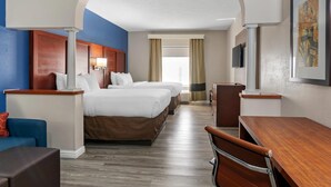 Une chambre d’hôtel avec un grand lit, un bureau, une chaise, une télévision et une fenêtre avec des rideaux.