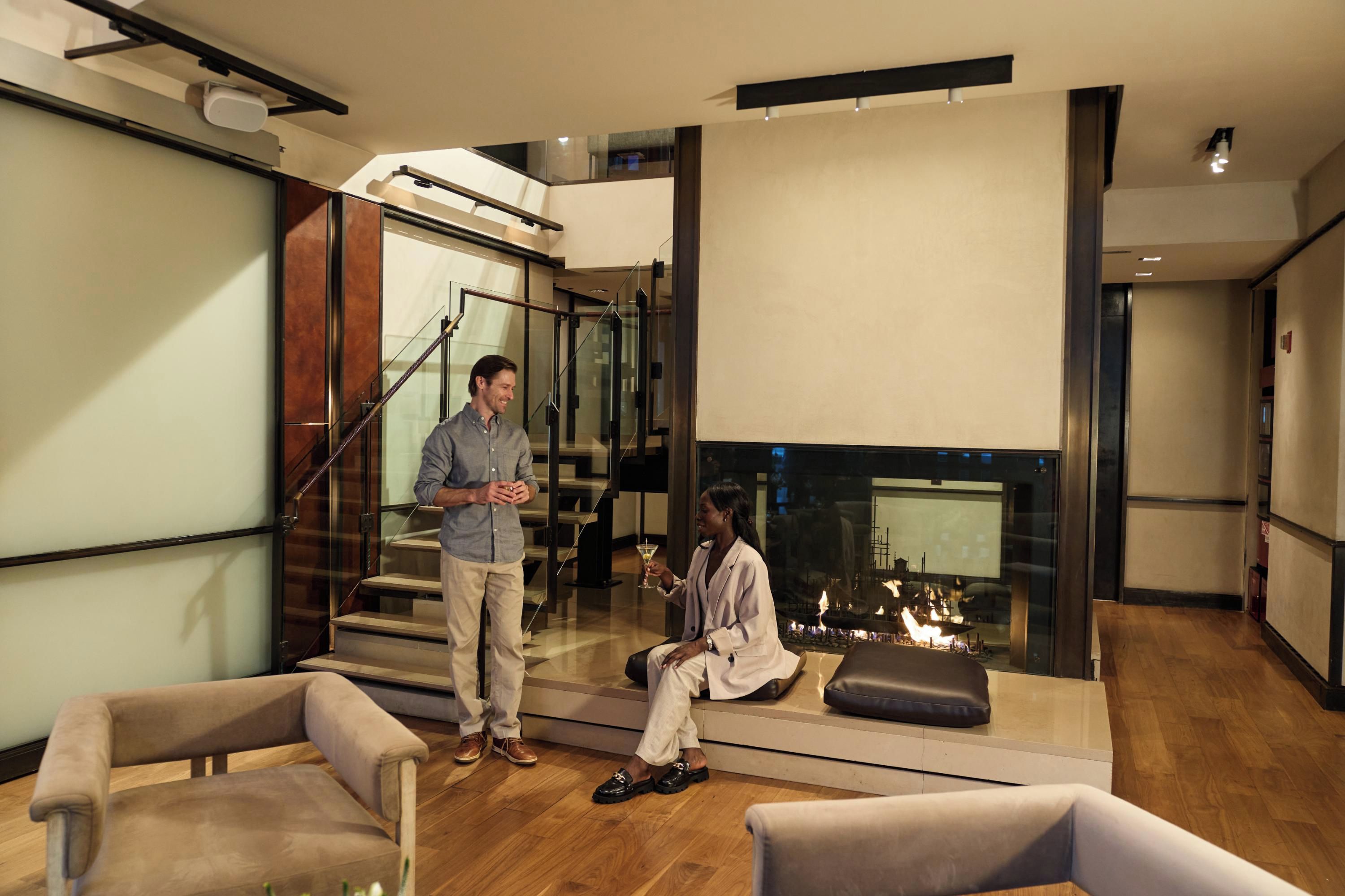 A modern interior with a staircase, seating area, and a fireplace.