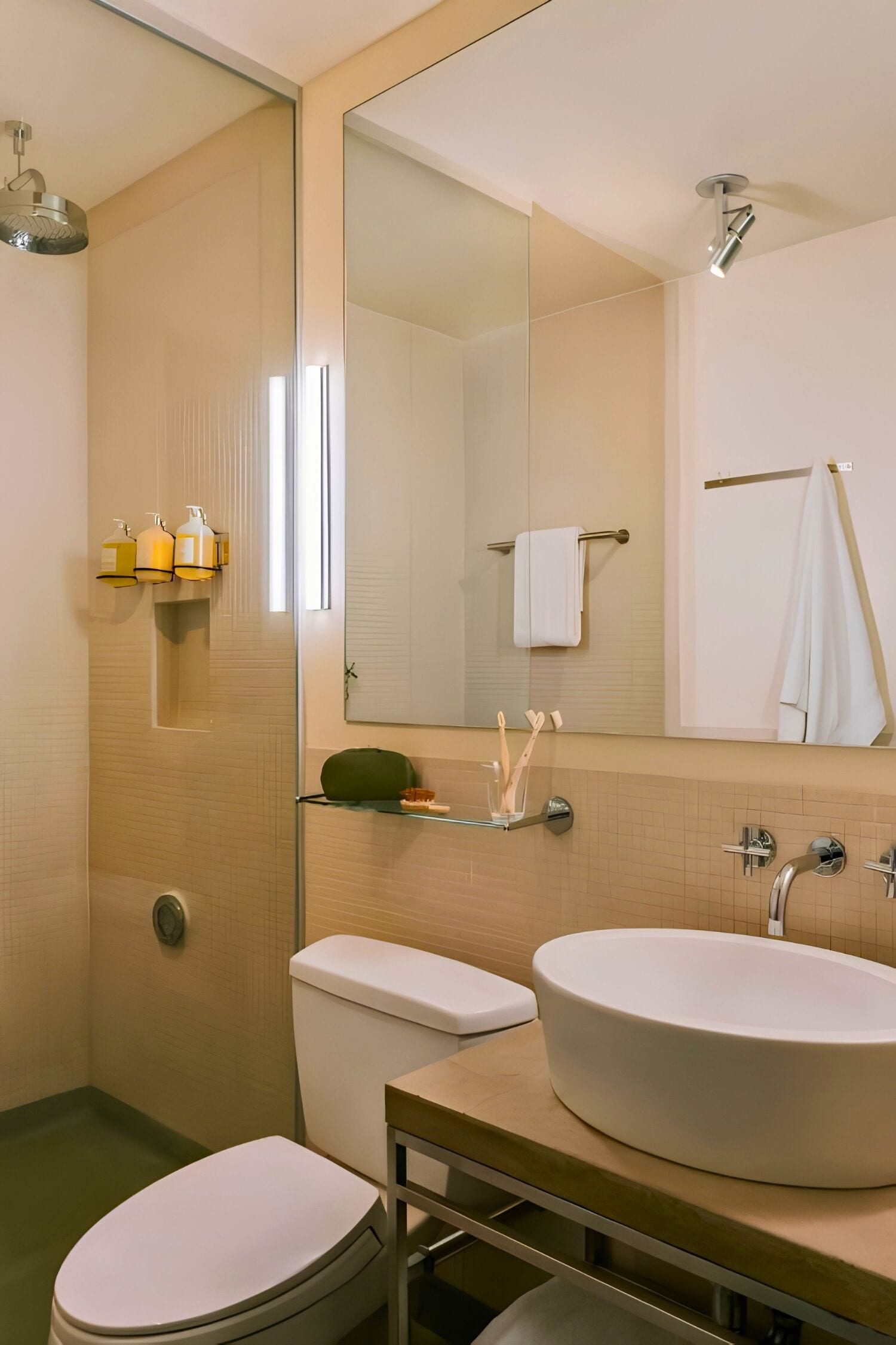 Ein Badezimmer mit Toilette, Waschbecken, Spiegel und Dusche.