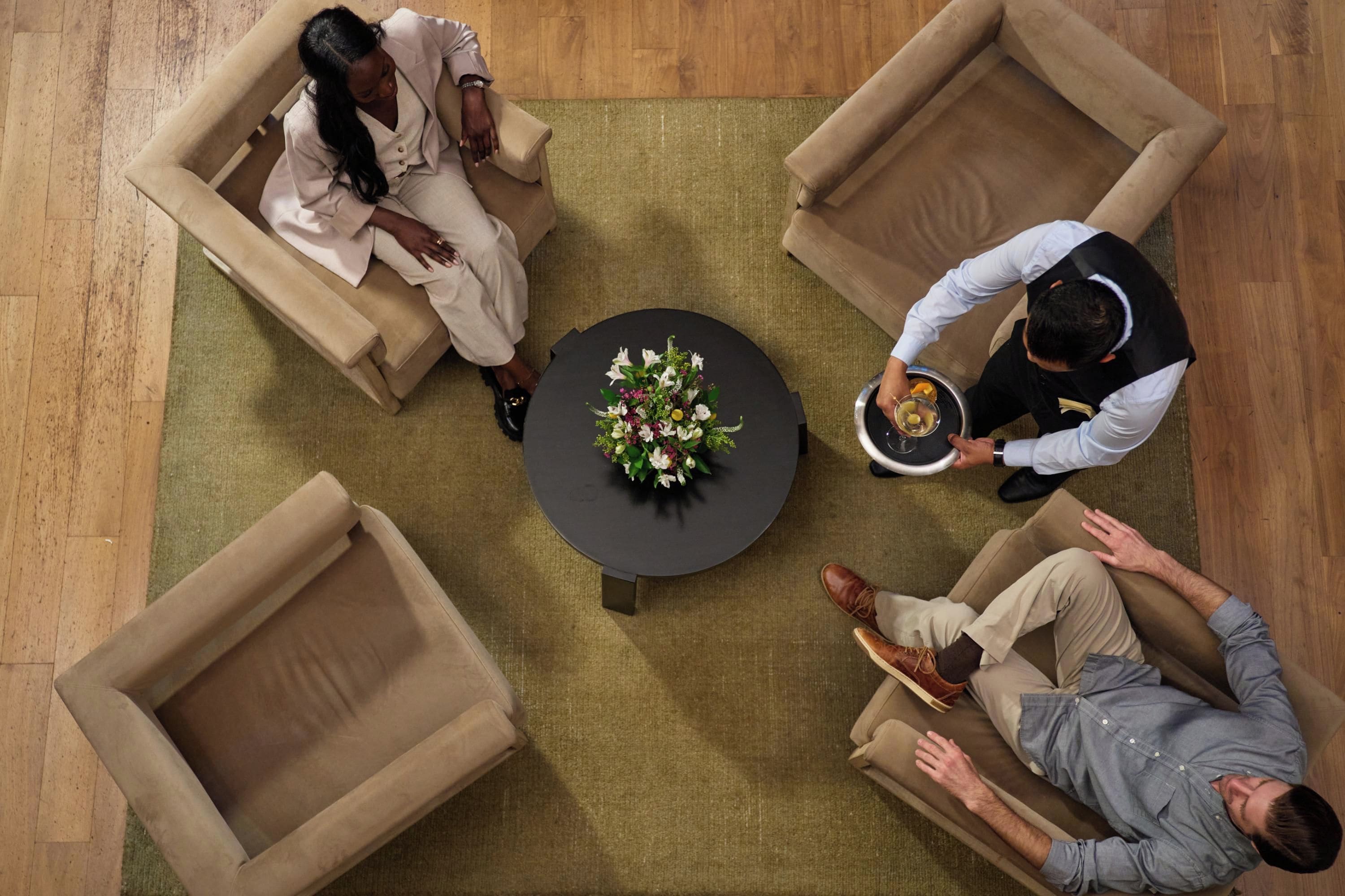 A room with a round table at the center, surrounded by four sofas.