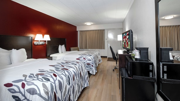 Une chambre d’hôtel équipée d’un lit, d ’un bureau, d’une chaise, d’une télévision et d’une machine à café.