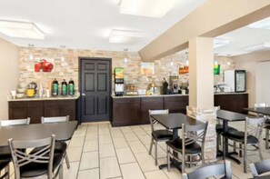 A modern restaurant with a stone wall backsplash, dark wooden cabinets, and a variety of seating options including tables and chairs. - Quality Inn Middleburg Heights near Cleveland Airport (Middleburg Heights)