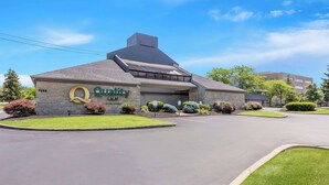 A hotel with a stone facade, a large parking lot, and well-maintained landscaping. - Quality Inn Middleburg Heights near Cleveland Airport (Middleburg Heights)