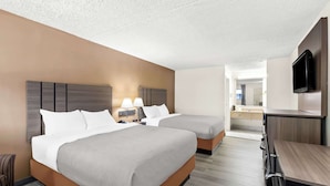 A hotel room with two beds, a desk, and a TV. - Quality Inn Middleburg Heights near Cleveland Airport (Middleburg Heights)