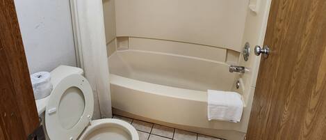 Un baño con inodoro, bañera y ducha.