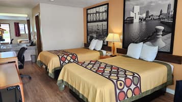 A hotel room with two beds, a desk, a chair, a lamp, and a cityscape painting.
