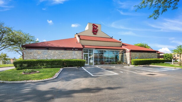 A Red Roof Inn with a stone facade, a red roof, and a parking lot. - Red Roof Inn Columbus - Grove City (Grove City)