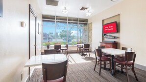 A conference room with a large window, a flat-screen TV, and a sign indicating free Wi-Fi availability. - Red Roof Inn Columbus - Grove City (Grove City)