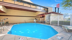 Piscina externa com cadeira de salva-vidas, placa de proibição de mergulho e placa da Red Roof Inn.