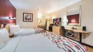 A hotel room with two beds, a desk with a computer, a mirror, and a TV. - Red Roof Inn Columbus - Grove City (Grove City)