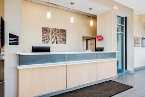 A reception desk with a check-in/out sign, a digital display, and a 'Free Wi-Fi All Rooms' sign. - Red Roof Inn Columbus - Grove City (Grove City)