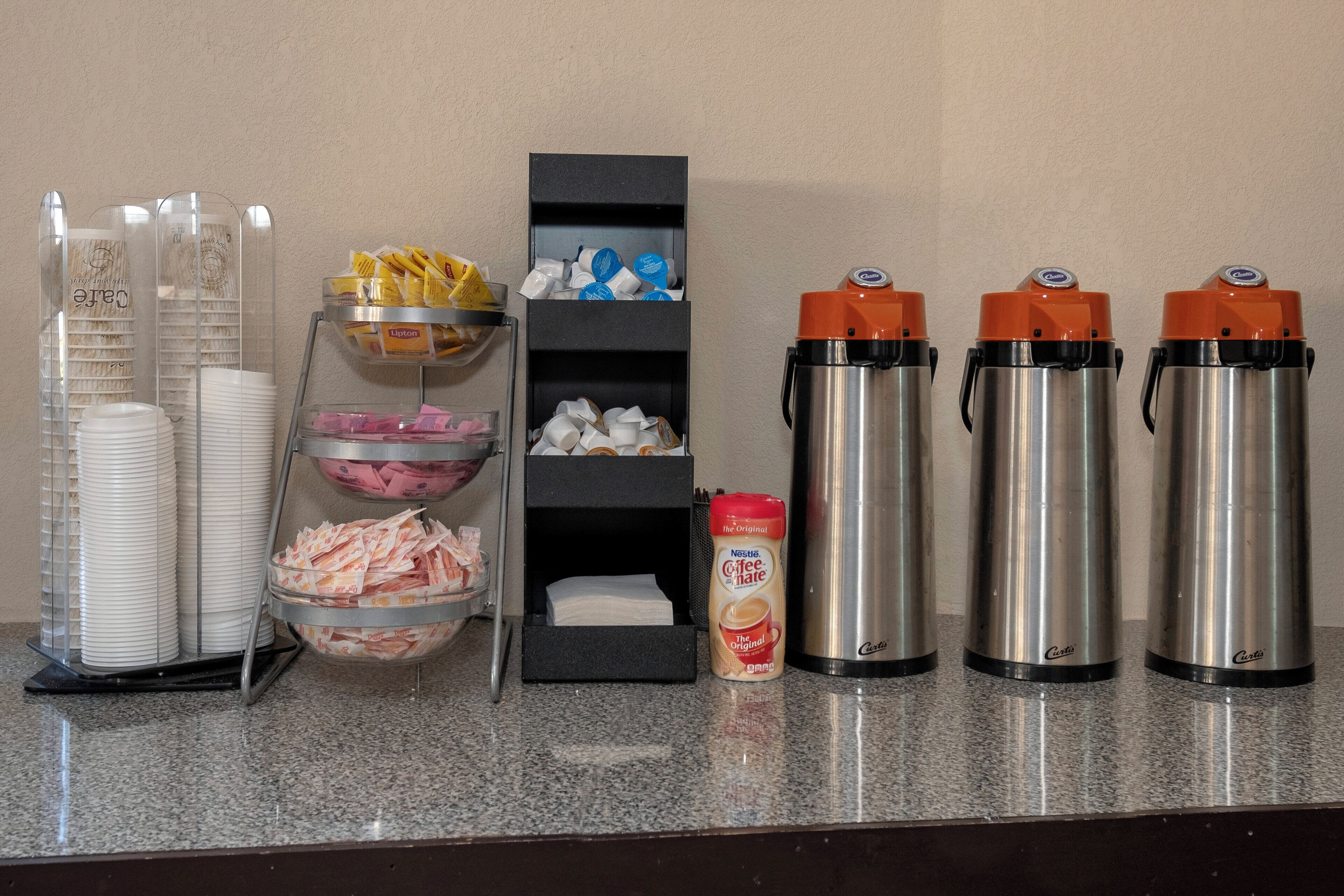 A buffet setup with various food items and condiments.