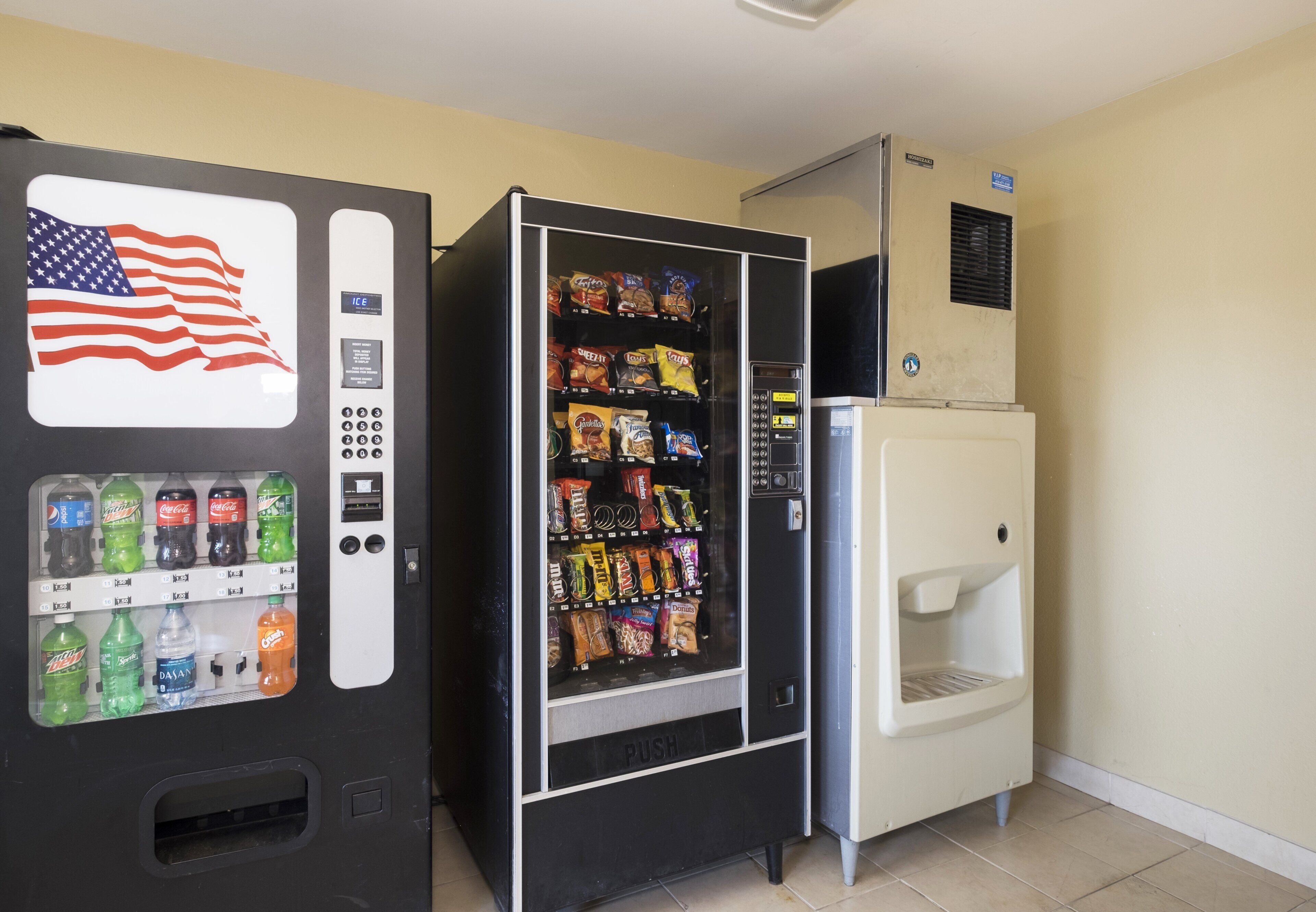 A vending machine with an American flag design, a water dispenser, and a variety of snack options.