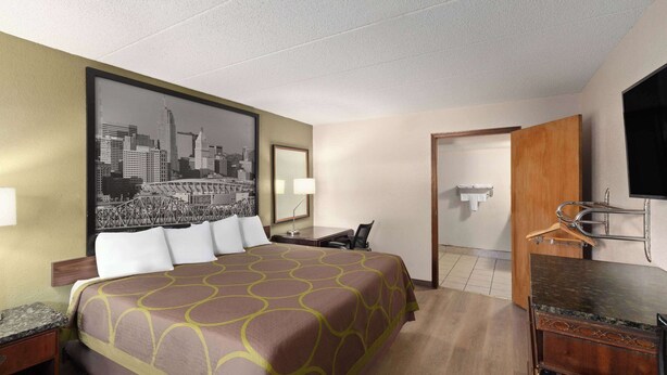 A hotel room with a large bed, a desk, a chair, a TV, and a bathroom. - Super 8 by Wyndham Fort Mitchell Cincinnati Area (Fort Mitchell)