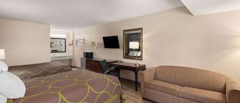 Habitación de hotel con dos camas, un escritorio, una silla, un sofá, un televisor y un espejo.