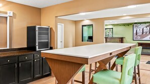 A modern kitchen with a large island, black cabinets, and a white countertop. - Super 8 by Wyndham Cincinnati/Springdale OH (Cincinnati)