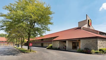 A motel with a stone facade, a red roof, and a sign indicating it is a Holiday Inn Express.