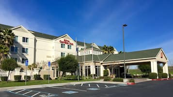 A hotel with a large entrance, handicap parking, and a covered waiting area.