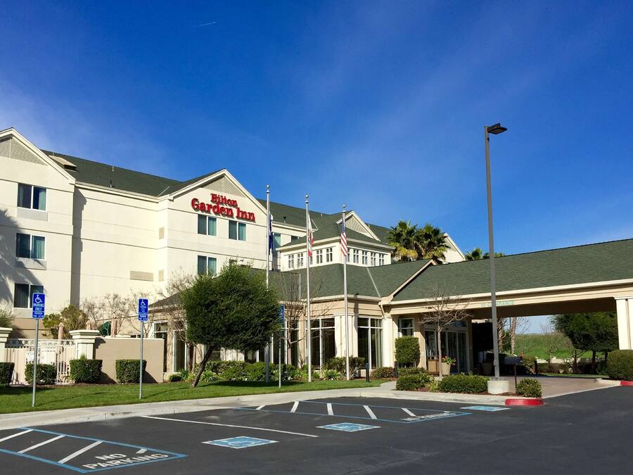 A hotel with a large entrance, handicap parking, and a covered waiting area.