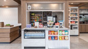 A modern retail kiosk with a variety of snacks, beverages, and a coffee machine.