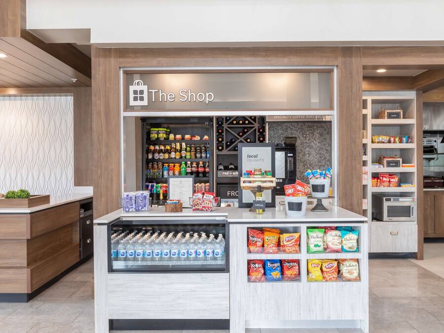 A modern retail kiosk with a variety of snacks, beverages, and a coffee machine.