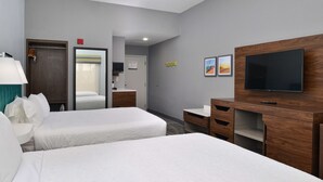A hotel room with two beds, a TV, a desk, and a mirror. - Hampton Inn Panama City Beach (Panama City Beach)